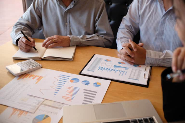 two people at a business meeting reviewing report data